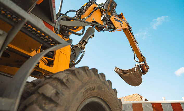Gelber Mobilbagger von Christian Knoch Tiefbau bei Erdarbeiten auf einer Baustelle.