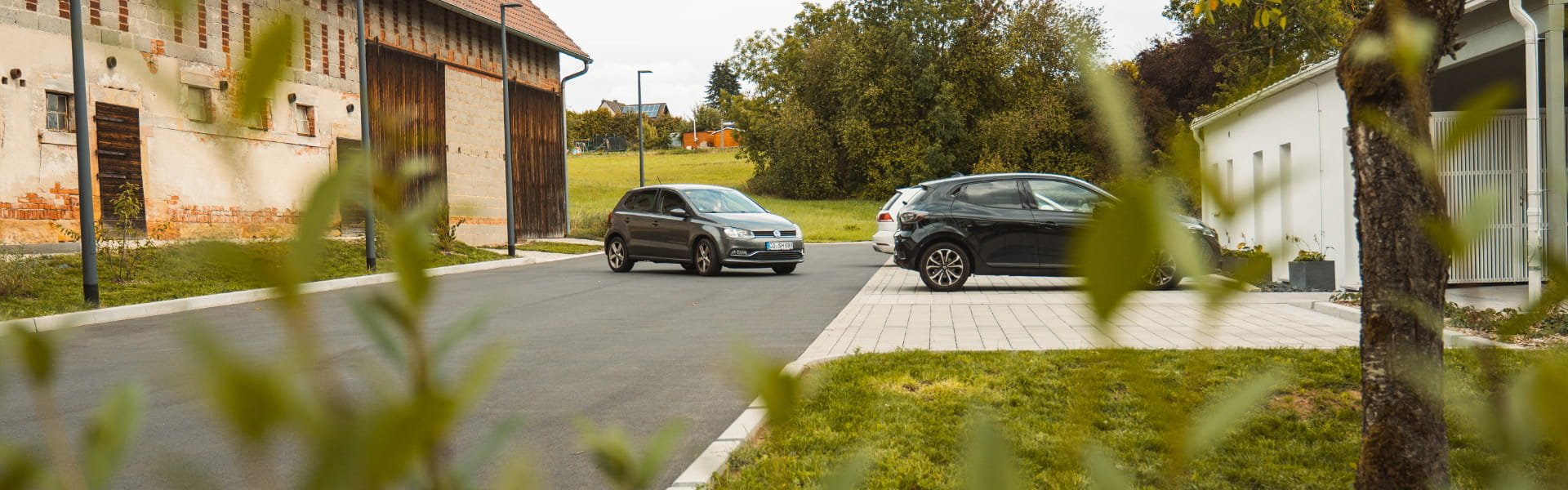 Neu gestalteter Parkplatz mit gepflasterten Stellflächen und asphaltierter Zufahrt vor einer Zahnarztpraxis.