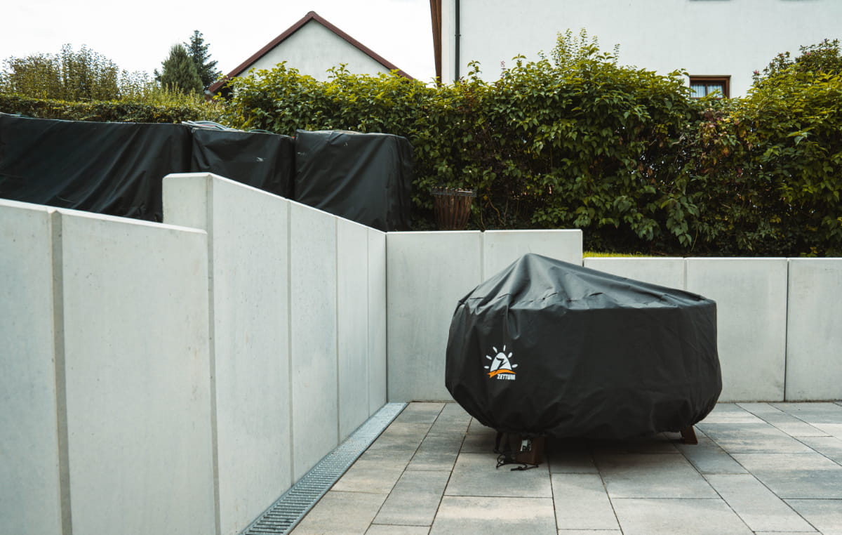 Gepflasterter Hofbereich mit hellen Beton-Randsteinen als abgestufte Einfassung.