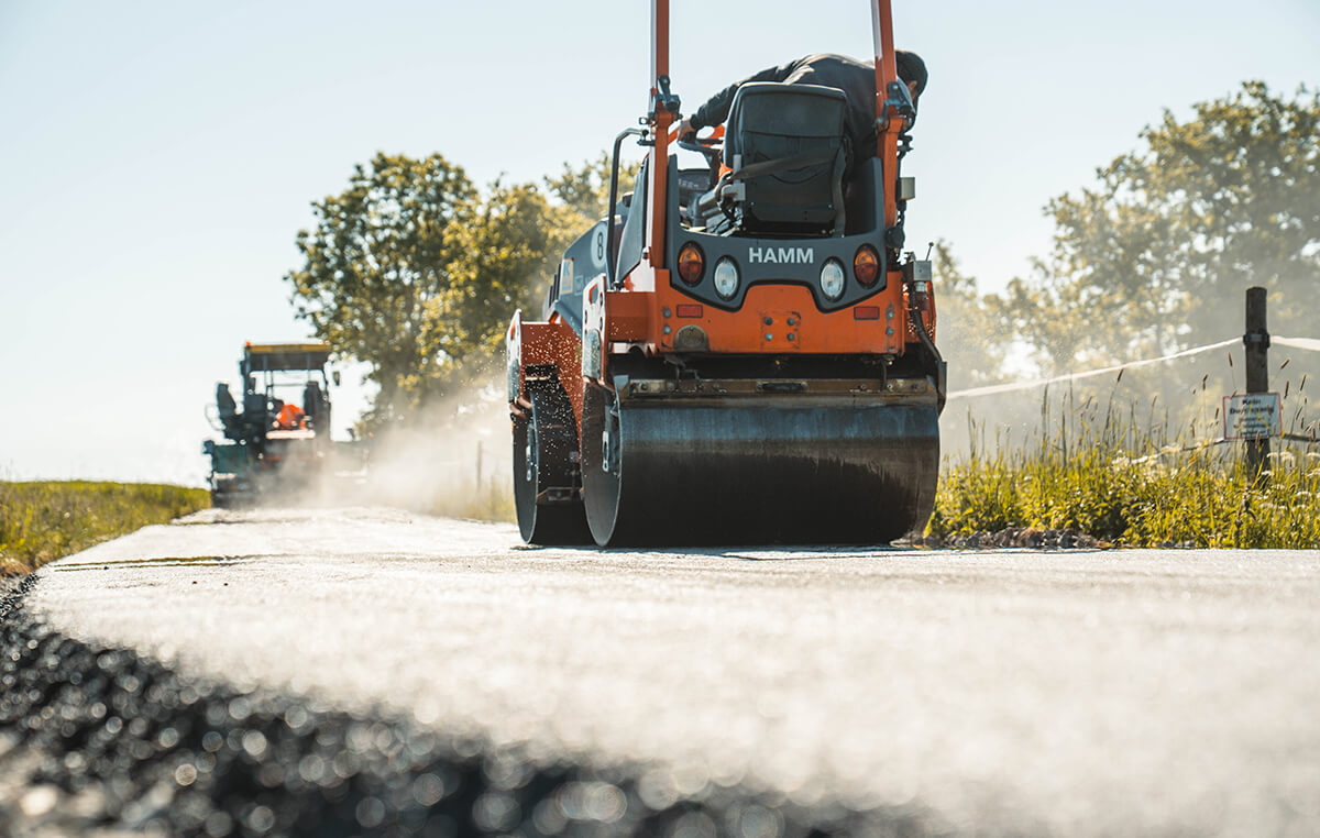 Straßenwalze bei der Verdichtung der neu eingebauten Asphaltfläche am Wirtschaftsweg Kösfelder Höhe in Beiersdorf.